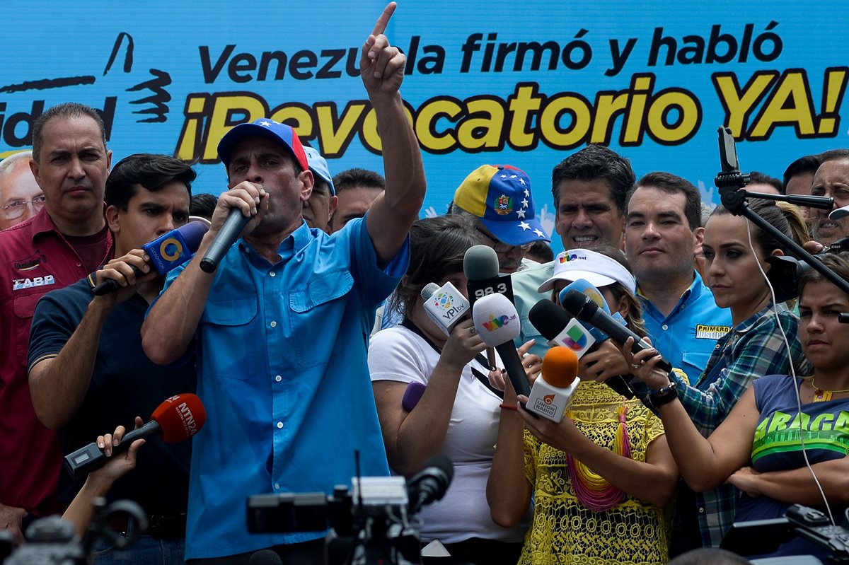 El líder opositor (al micrófono), Henrique Capriles, durante una concentración para exigir la salida de Nicolás Maduro del poder. (Foto Prensa Libre: AFP).