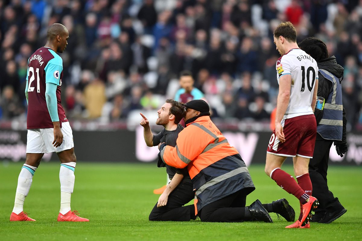 Un aficionado logró llegar al centro del campo para recriminarle al italiano Angelo Ogbonna su supuesta falta de compromiso con el equipo. (Foto Prensa Libre: AFP)