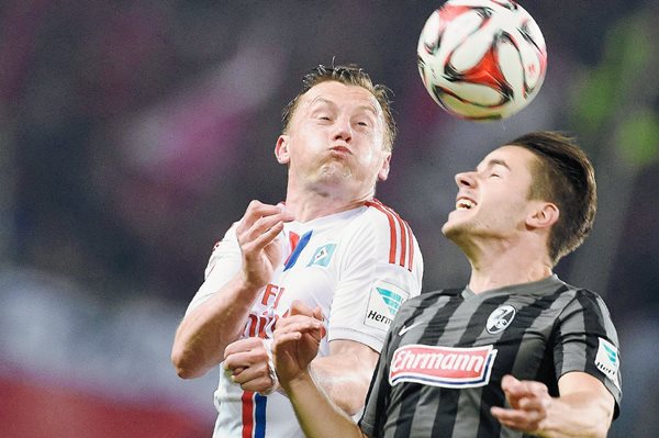 Ivica Olic del Hamburgo —izquierda— y Christian Guenter, durante el juego de ayer en el arranque de la fecha en la Bundesliga. (Foto Prensa Libre: EFE)