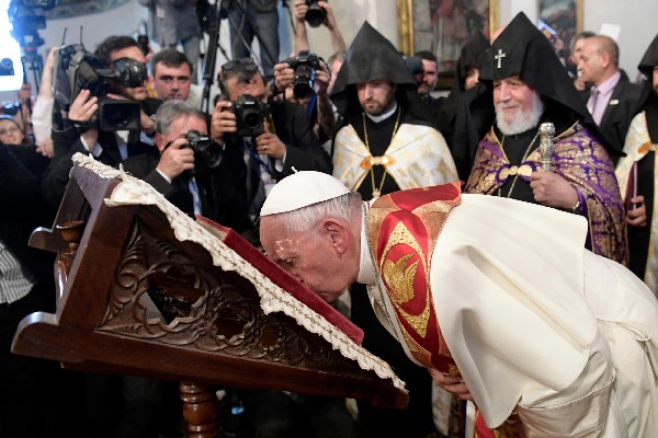 Francisco besa la biblia durante su visita a la catedral en Ereván, Armenia. (Foto Prensa LIbre:AP).