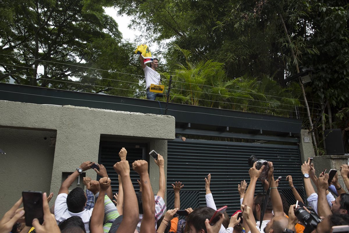 El líder opositor venezolano Leopoldo López (c) saluda a seguidores hoy afuera de su residencia en Caracas, Venezuela. (Foto Prensa Libre: EFE).