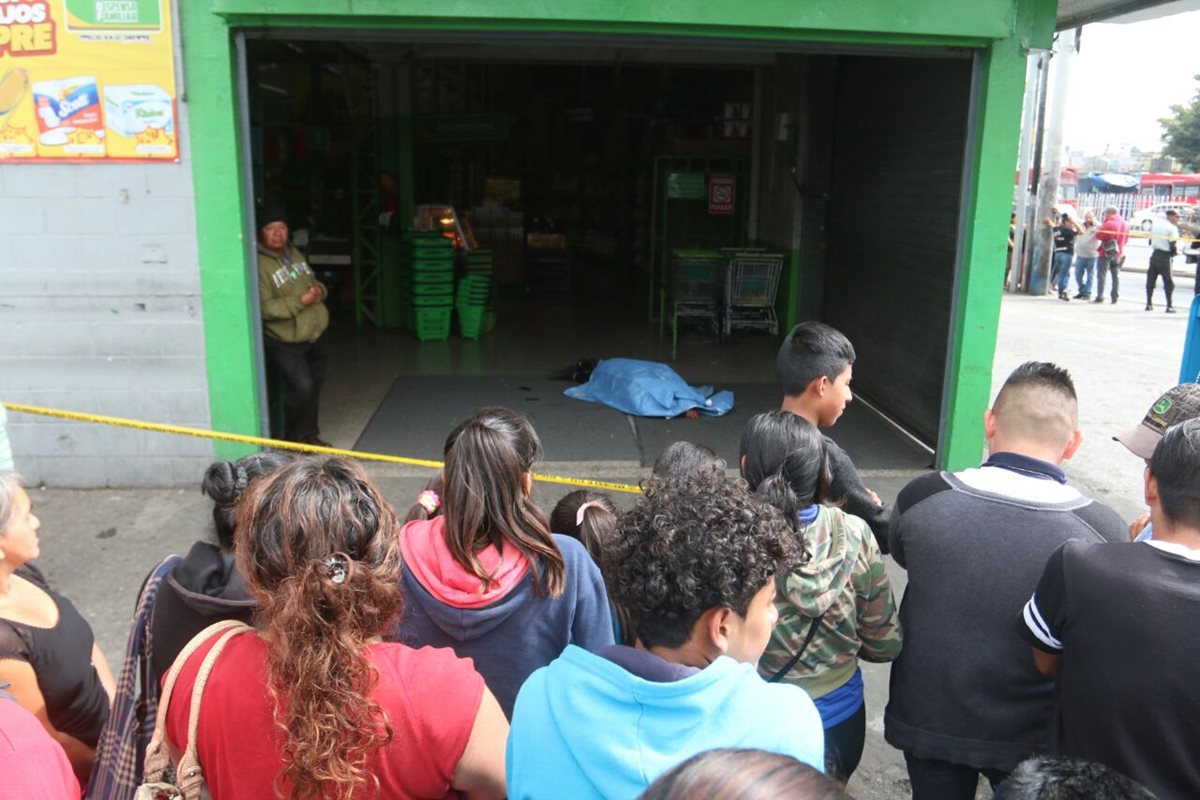 Una de las persona muertas en el ingreso de un supermercado ubicado en la Calzada San Juan, colonia La Florida, zona 19. (Foto Prensa Libre: Cortesía)