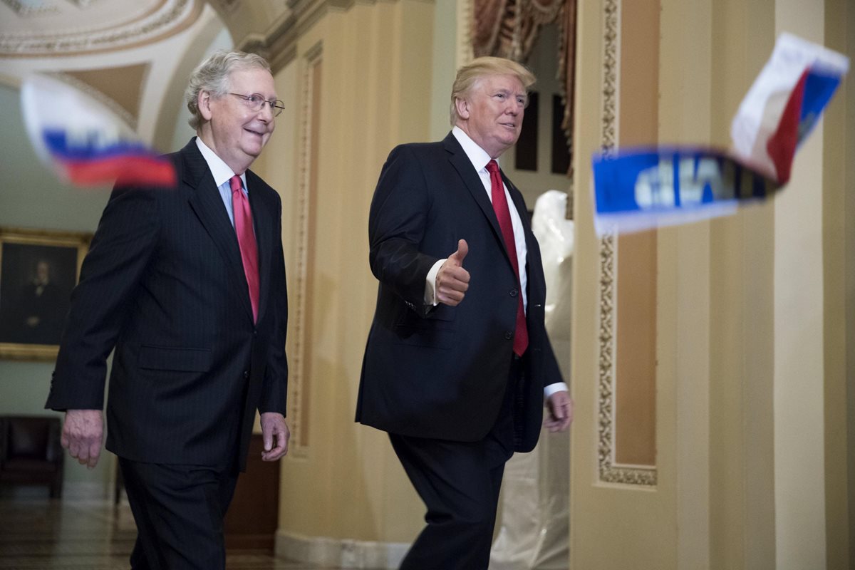 Un puñado de banderas rusas con el nombre de Trump es lanzado por un manifestantes contra el presidente en el Capitolio. (Foto Prensa Libre: EFE)