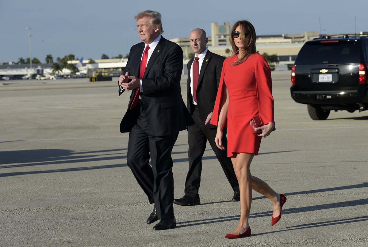 En este instante, el presidente Trump ya soltó la mano de su esposa Melania Trump para saludar a los simpatizantes. (Foto Prensa Libre: AP)