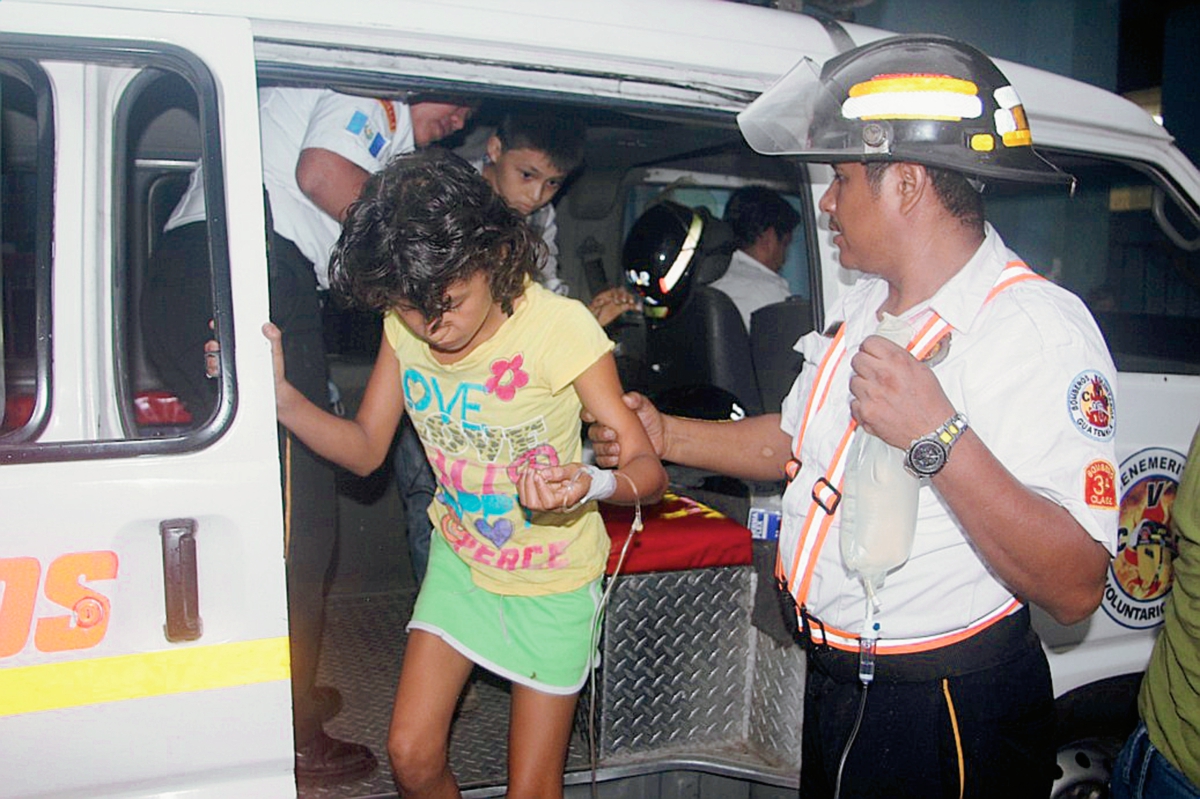 Bomberos atienden a una de las estudiantes afectadas en Santa Lucía Cotzumalguapa, Escuintla. (Foto Prensa Libre: Melvin Sandoval)