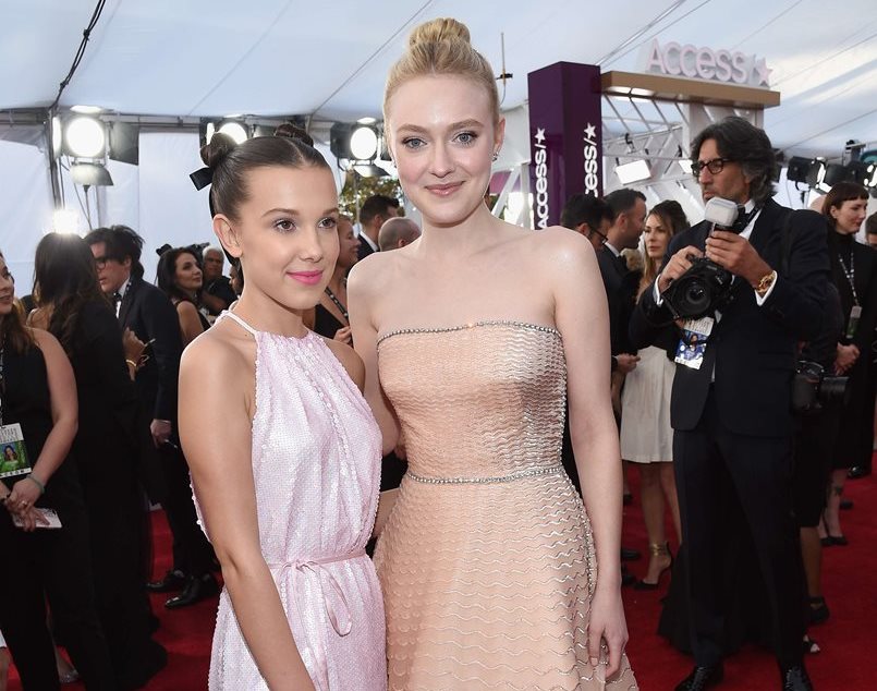 Millie Bobbie Brown y Dakota Fanning en su paso por la alfombra roja. Las actrices lucieron elegantes vestidos en tonos suaves, que fueron la tendencia en la alfombra roja. (Foto Prensa Libre: AFP).