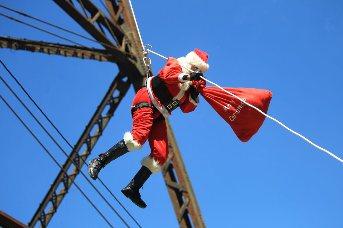 Santa Claus bajó del puente Las Vacas en la zona 5 para dar regalos a niños que viven en asentamientos. (Foto Prensa Libre: Esbin Gacía)