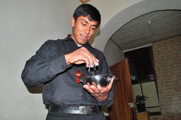 Ángel López, seminarista,  verifica la textura de la ceniza, en la parroquia El Calvario de Xela.