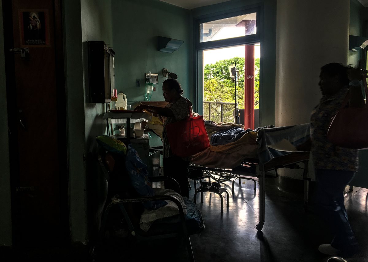 Familiares acompañan a un paciente en una sala del Hospital Universitario de Caracas. (AFP)