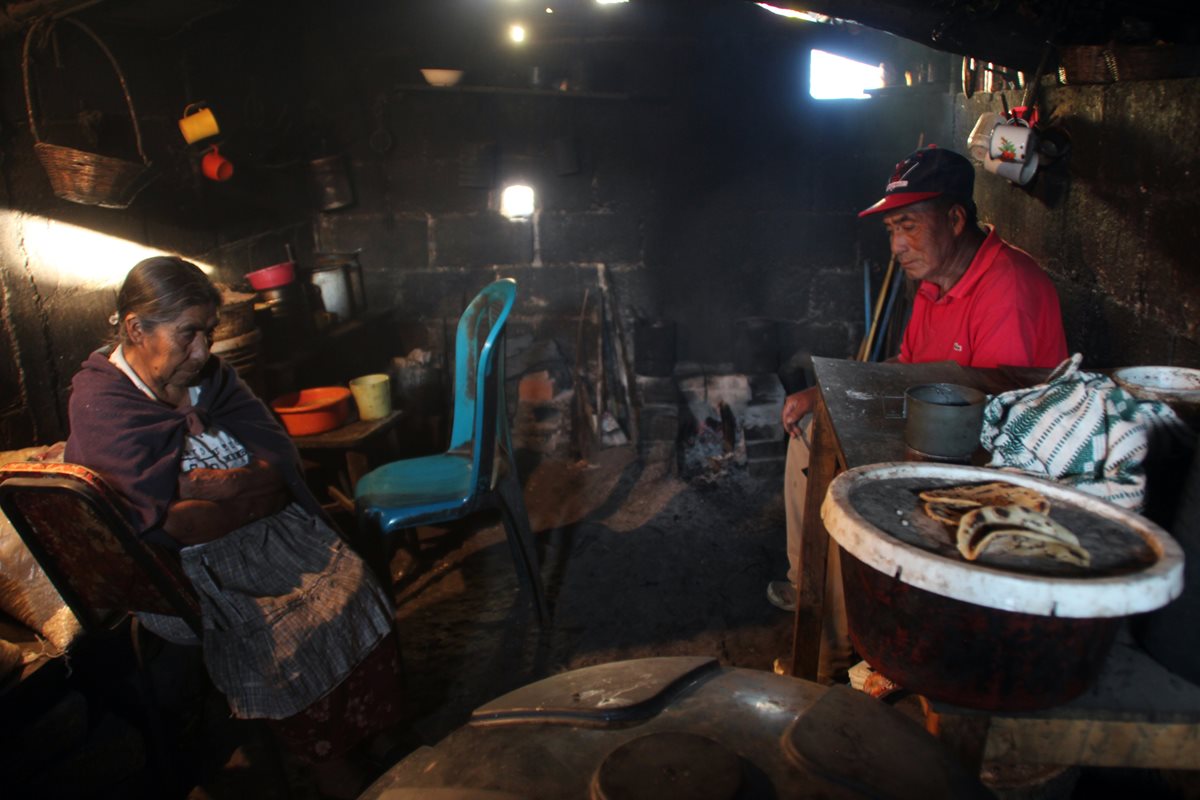 Maximiliana García y su esposo Catalino, quienes cuidan el cementerio de la zona 3 de Huehuetenango, se disponen a almorzar en su vivienda. (Foto Prensa Libre: Mike Castillo)