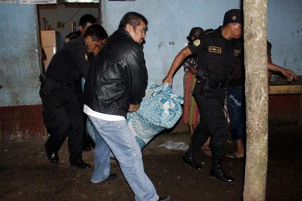Agentes de la PNC trasladan el cuerpo.