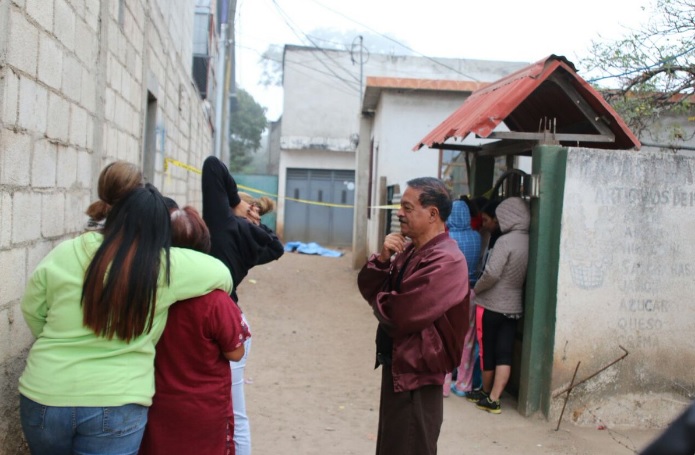 Vecinos de Boca del Monte observan el cadáver de la mujer que fue hallado en esa localidad. (Foto Prensa Libre: Cortesía)