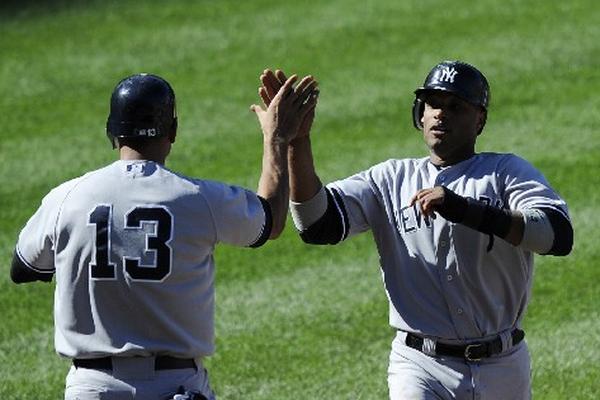 Robinson Cano es felicitado por Álex Rodríguez en una acción del juego de los Yanquis frente a los Orioles. (Foto Prensa Libre: AP)