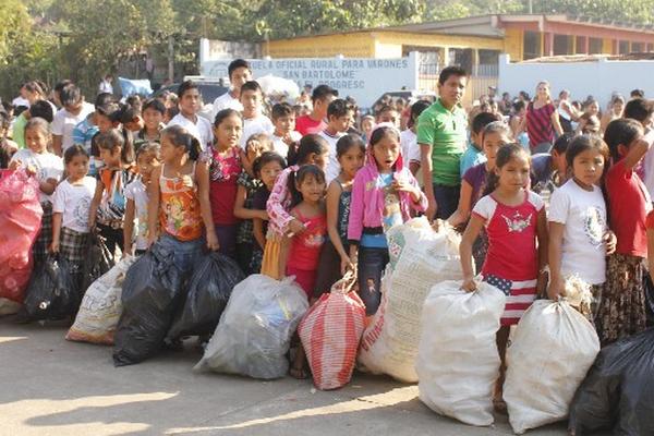 Niños forman fila para cambiar envases.