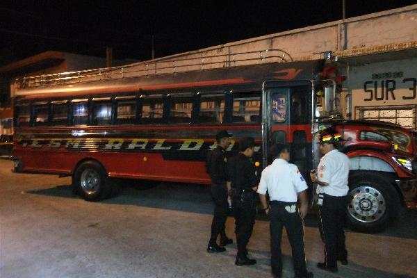 Agentes examinan   el autobús asaltado.