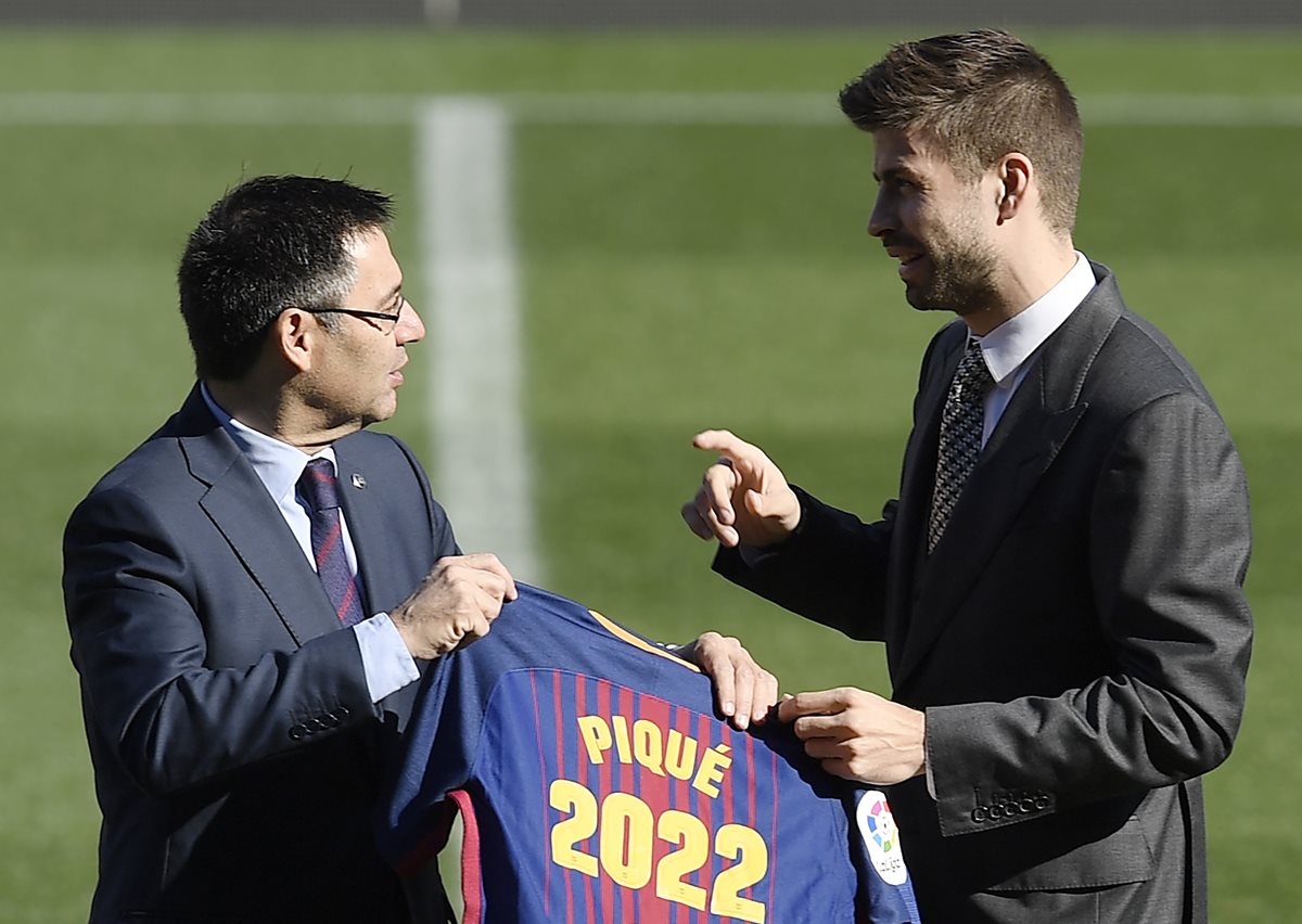 Josep María Bartomeu conversa con Gerard Piqué en el centro del campo después de haber firmado el contrato de renovación. (Foto Prensa Libre: AFP)