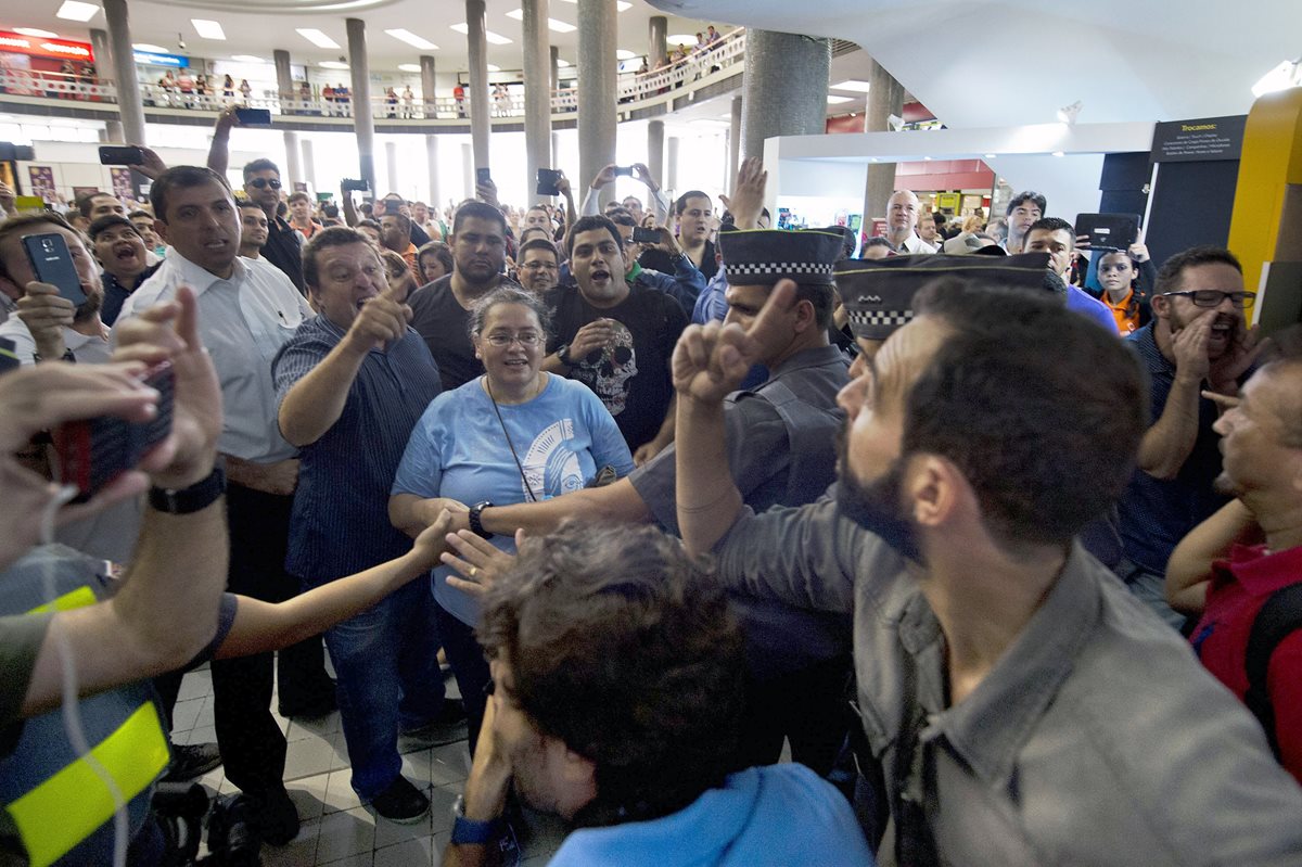 Opositores (i) y simpatizantes (d), de Lula da Silva cruzan insultos frente a la sede de la Policía de Sao Paolo donde el expresidente prestó declaración. (Foto Prensa Libre; AFP).