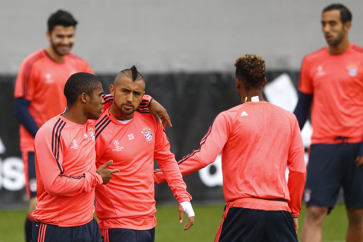 Douglas Costa abraza a su compañero Arturo Vidal, en el último entreno del Bayern Munich antes de enfrentarse al Atlético de Madrid. (Foto Prensa Libre: AP)