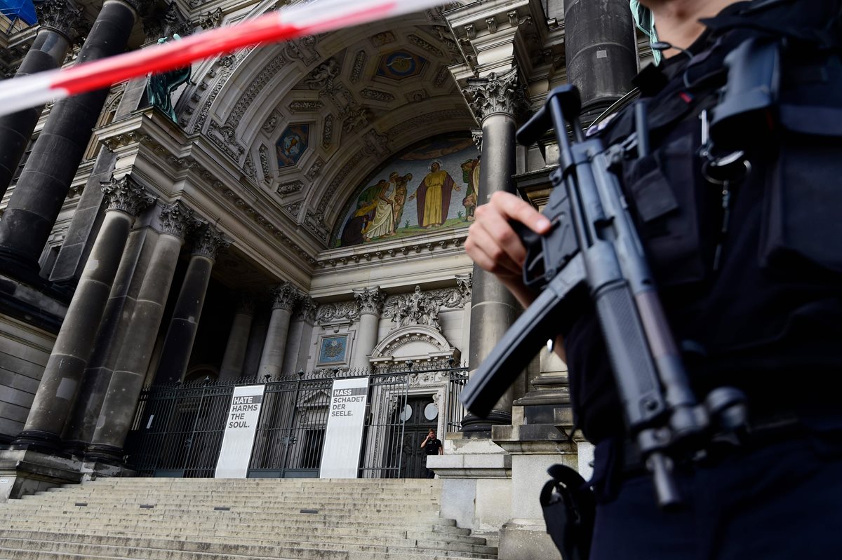 Un policía armado en la entrada principal de la catedral que luce acordonada. (Foto Prensa Libre: AFP)