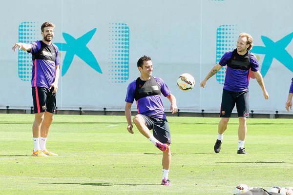 Los jugadores del FC Barcelona Gerard Piqué, Xavi Hernández e Ivan Rakitic durante el entrenamiento que la plantilla azulgrana realizó este viernes. (Foto Prensa Libre: EFE)