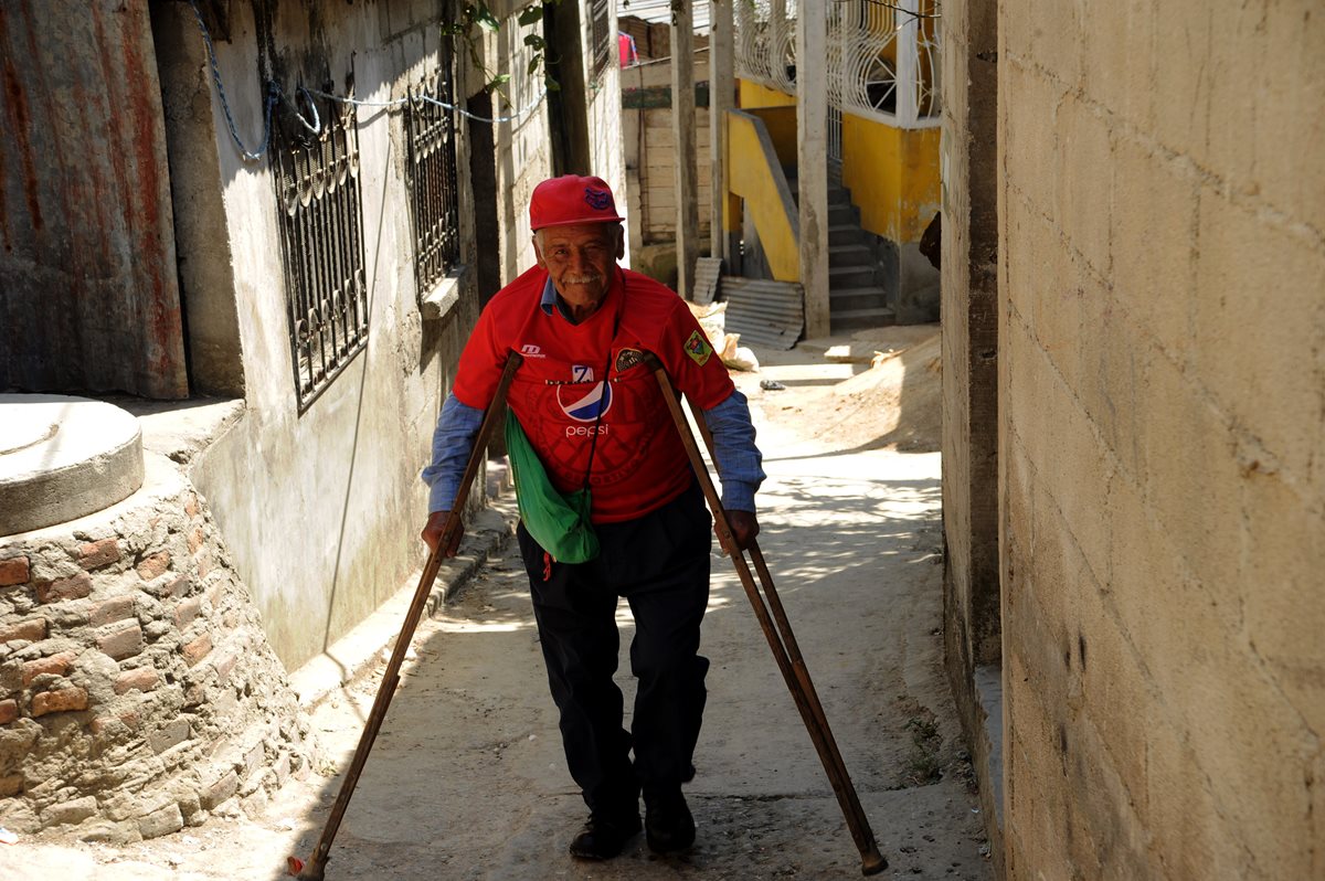 Los angostos allejones y las pronunciadas gradas del asentamiento Veinticuatro de Diciembre no son obstáculo para que Higinio asista a ver a sus amados rojos. (Foto Prensa Libre: Edwin Fajardo)