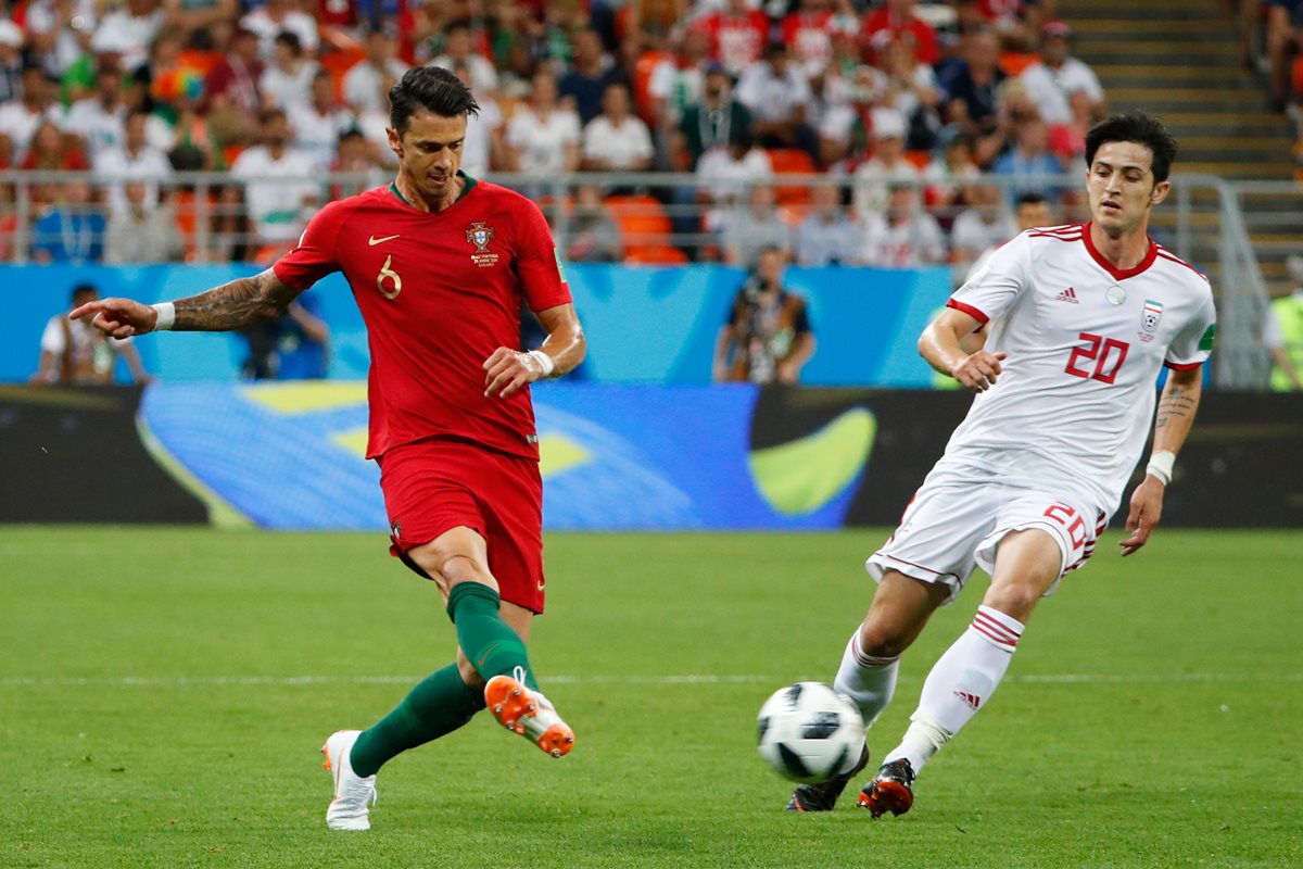 Jose Fonte disputa un balón con el iraní Sardar Azmoun durante el duelo de esta tarde. (Foto Prensa Libre: AFP)