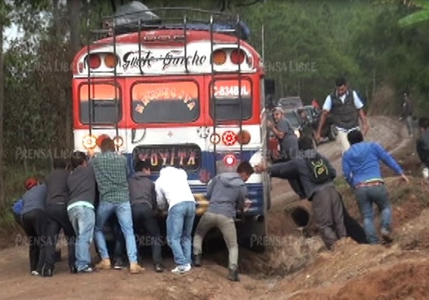 Pasajeros empujan un bus que se atascó en la ruta entre Chuiquisis y Santa Cruz del Quiché. (Foto Prensa Libre: Héctor Cordero).