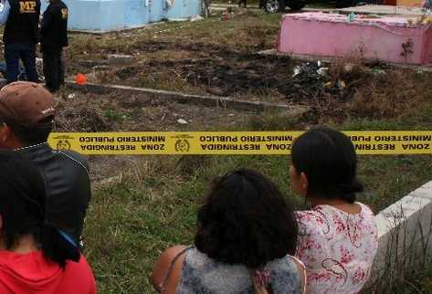 Curiosos observan tumba profanada.