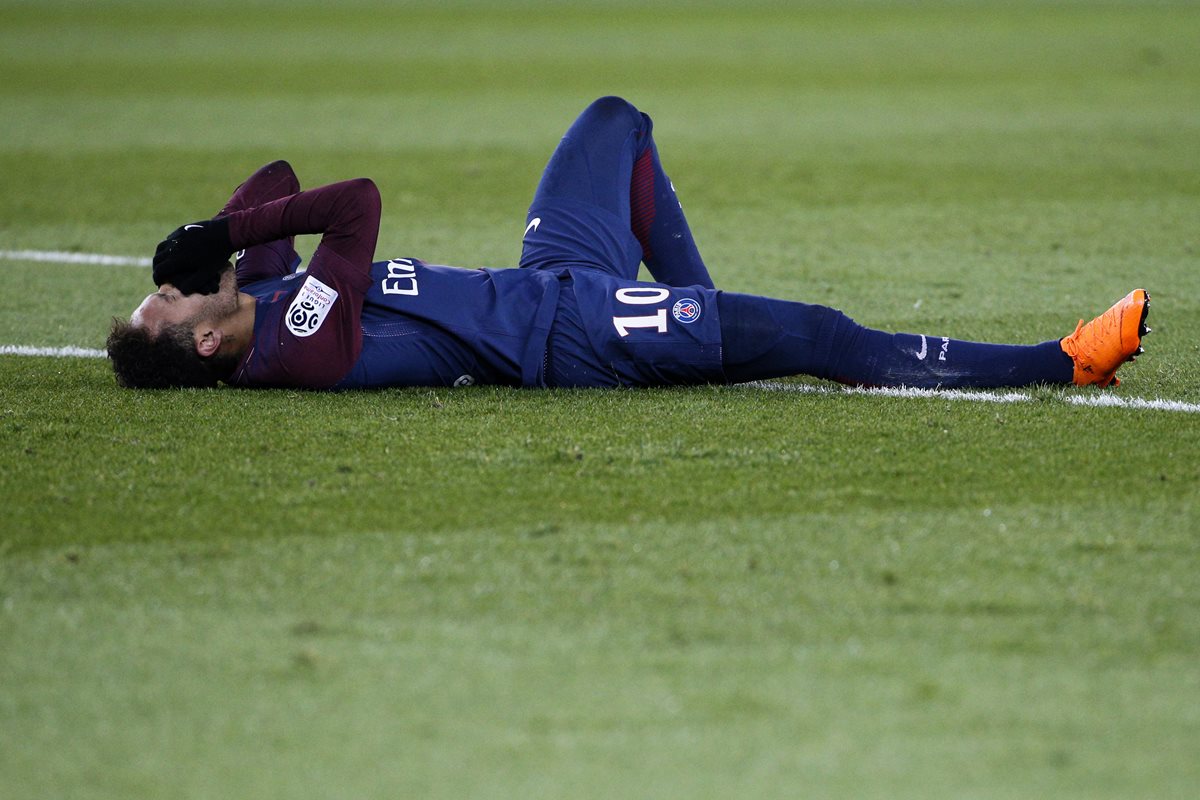 Neymar se lleva las manos al rostro después de lesionarse durante el partido entre PSG y el Marsella. (Foto Prensa Libre: AFP)