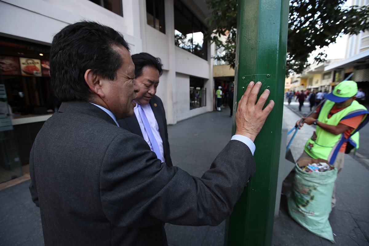 Dos personas no videntes verifican deterioro y daños a señalización para ciegos en el Paseo de la Sexta. (Foto Prensa Libre: Paulo Raquec)