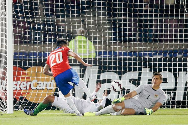 El centrocampista chileno Charles Aranguiz (i) dispara a puerta para marcar su segundo gol, tercero para el equipo de Chile, durante el partido Chile-Bolivia, del Grupo A de la Copa América, en el Estadio Nacional Julio Martínez de Santiago (Foto Prensa Libre: EFE)