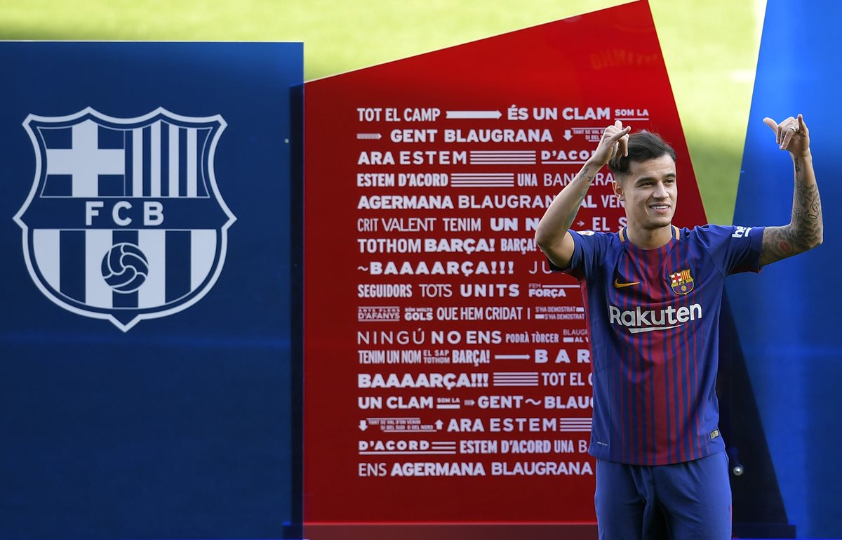 Philippe Coutinho saluda a los más de 10 mil aficionados que acudieron al Camp Nou para ver su presentación. (Foto Prensa Libre: AFP)