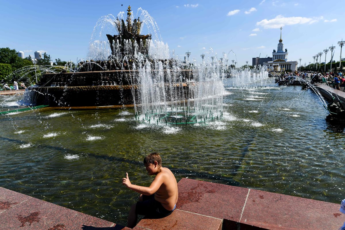 Un niño se refresca en una fuente en el All-Russia Exhibition Centre, con temperaturas de alrededor de 28 grados centígrados en Moscú. Rusia. (AFP)