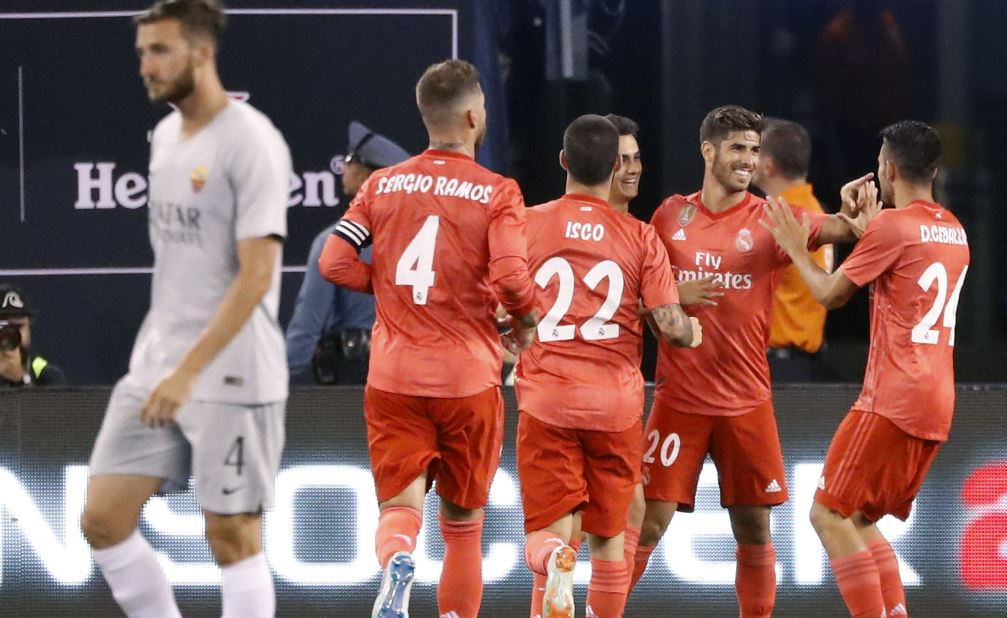 Marco Asensio, del Real Madrid celebra con sus compañeros luego de anotar el primer gol contra la Roma. (Foto Prensa Libre: AFP).