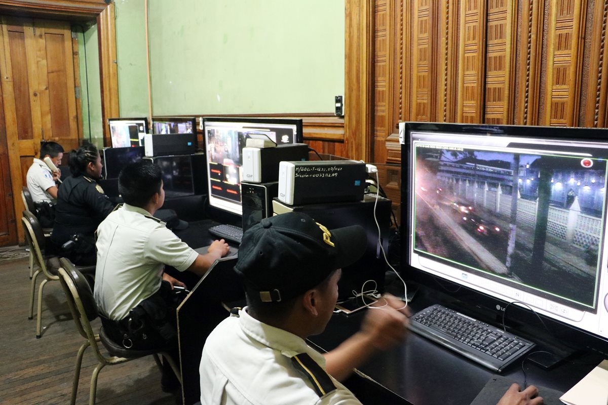 Agentes de la PNC monitorean el sistema de vigilancia en la sala instalada en la Gobernación Departamental de Quetzaltenango. (Foto Prensa Libre: Carlos Ventura)