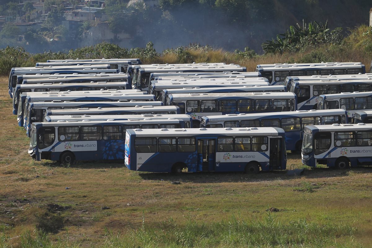 Unidades dañadas del Transurbano permanecen estacionadas en un predio de San Miguel Petapa. (Foto Prensa Libre: Hemeroteca PL)