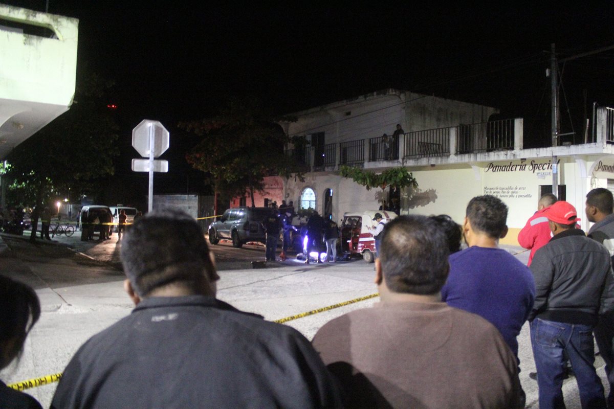Vecinos de Monjas, Jalapa, observan el trabajo de las fuerzas de seguridad en el lugar donde murió un piloto de mototaxi. (Foto Prensa Libre: Hugo Oliva)
