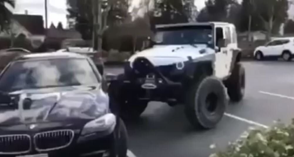 Momento en que un Jeep endereza a un BMW mal parqueado y termina por dañarlo. (Foto Prensa Libre: YouTube)