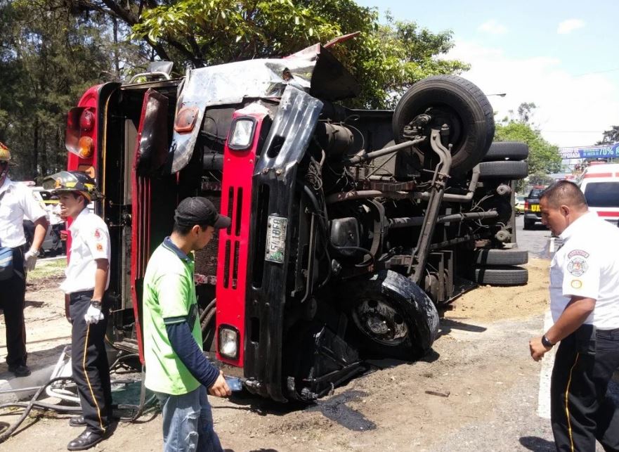 Bomberos permanecen en el lugar donde volcó el autobús. (Foto Prensa Libre: Cruz Roja)