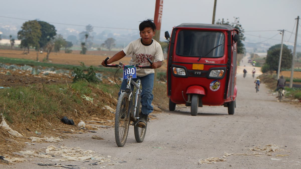 Édgar Estuardo Buch con sus botas de hule y su ropa de trabajo compitió en la segunda carera infantil de ciclismo. (Foto Prensa Libre: Cortesía Nery Ajsivinac)