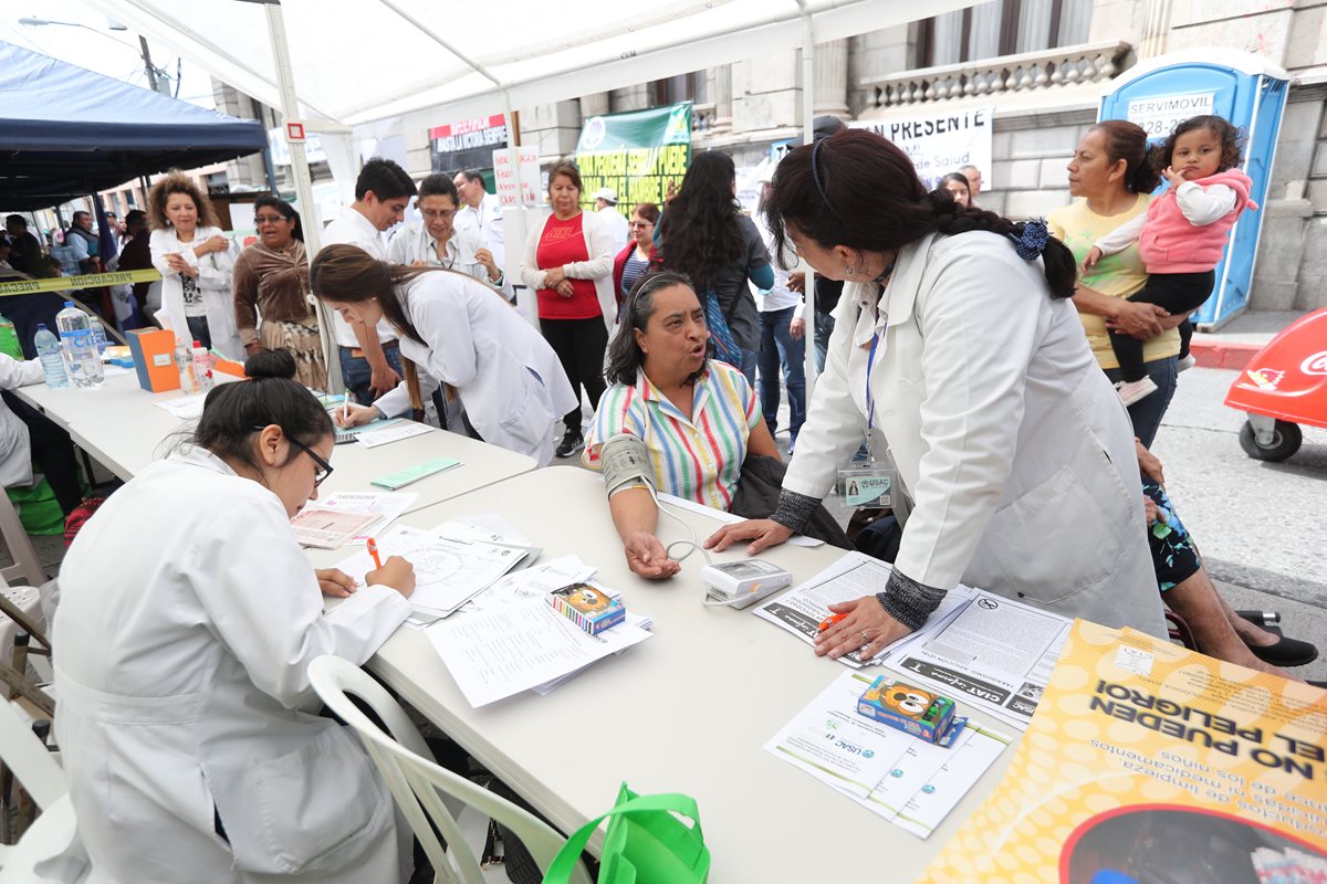 Estudiantes de la Escuela de Nutrición de la Usac prestan atención médica a varias personas en un campamento instalado frente al Congreso, como protesta por la reducción del presupuesto para el 2019 a esa casa de estudios. (Foto Prensa Libre: Érick Ávila)