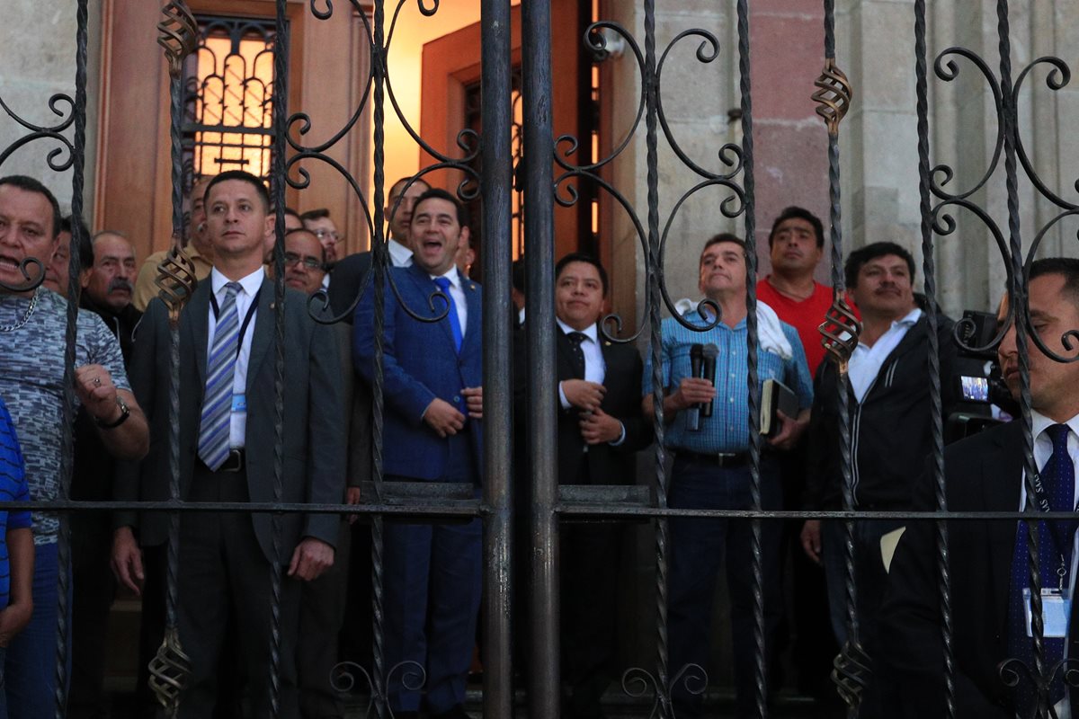 El presidente Jimmy Morales sale a saludar junto a Joviel Acevedo, representante del Magisterio, luego de reunión para pactar mejoras a los maestros. (Foto Prensa Libre: Carlos Álvarez)