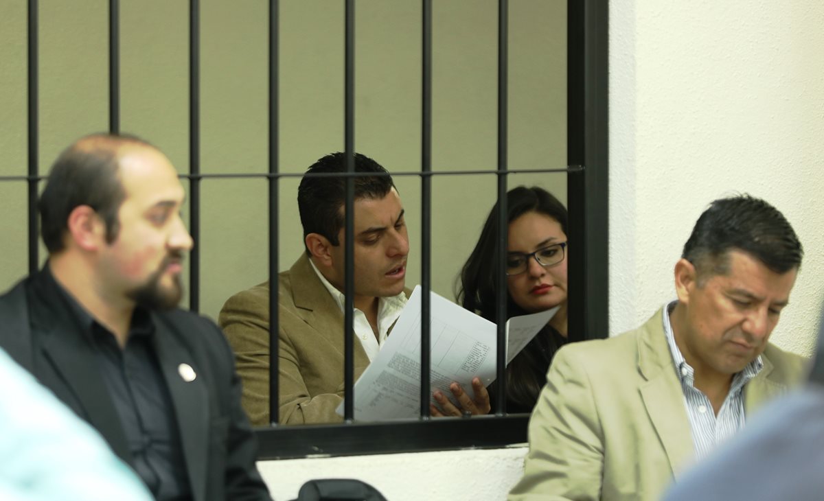 René Arturo Morales y su esposa Carmen Barrientos Salguero, yerno e hija del exalcalde de Xela, leen la acusación que les hace la Fiscalía Especial contra la Impunidad. (Foto Prensa Libre: Mynor Toc) 