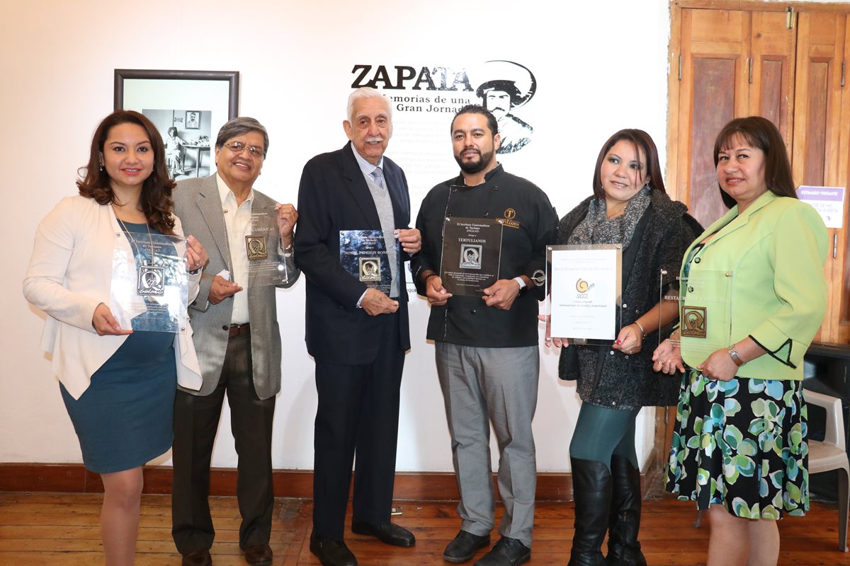 Los representantes de las empresas quetzaltecas presentan la plaqueta que recibieron por los estándares de calidad en el servicio. (Foto Prensa Libre: Raúl Juárez)