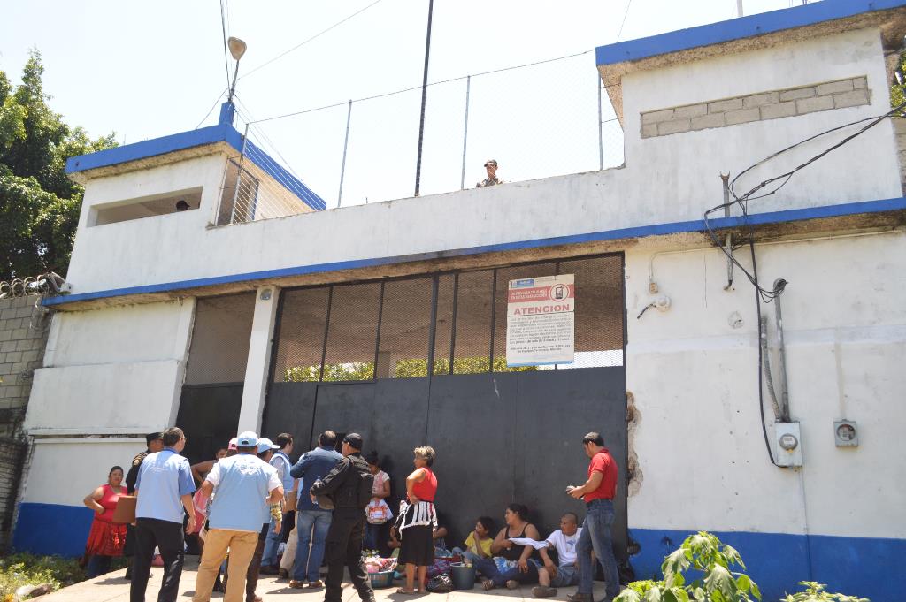 Algunas personas permanecen en el ingreso a la cárcel de El Boquerón, con la intención de dejar alimentos a los internos. (Foto Prensa Libre: Oswaldo Cardona).