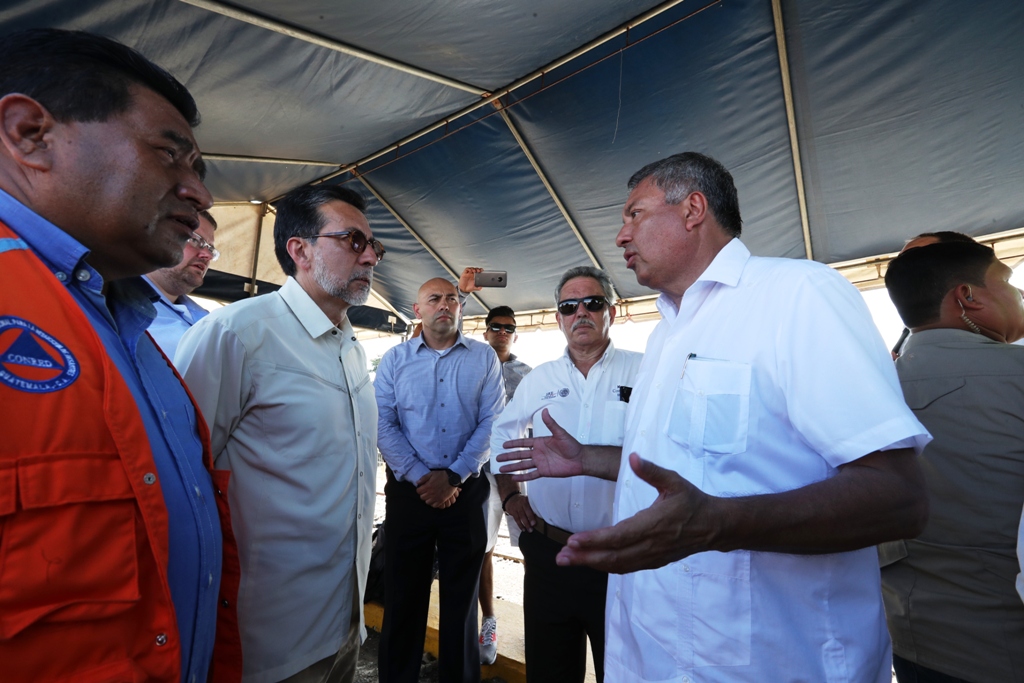 Los embajadores en Guatemala de EE. UU., Luis Arreaga (i) y de México, Manuel López (d), hablan durante una improvisada reunión en el paso fronterizo de Tecún Umán. (Foto Prensa Libre: Mynor Toc)