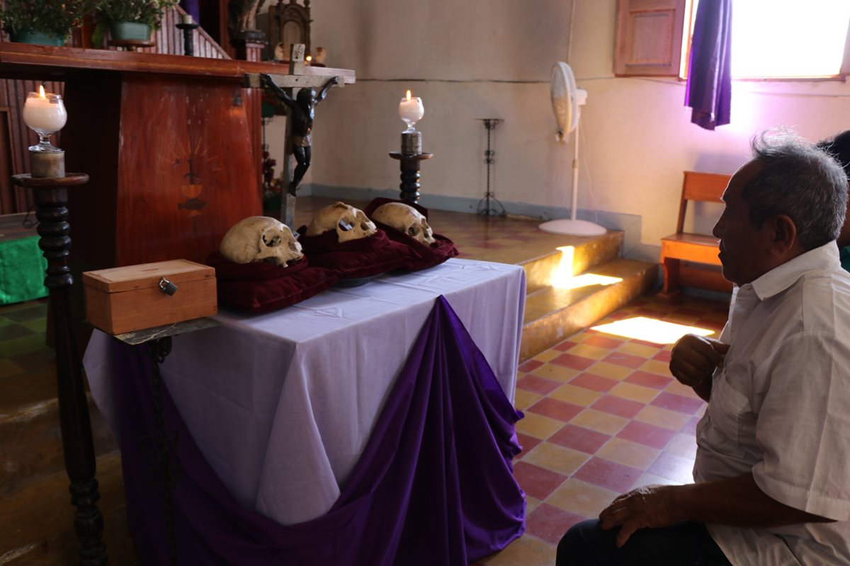 Un hombre ora frente a las tres calaveras en iglesia de San José, Petén. (Foto Prensa Libre: Rigoberto Escobar)