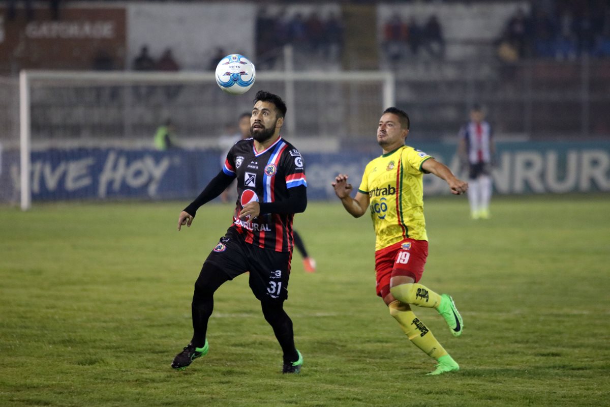 Ricardo Rocha observa el balón con la marca de Jonathan Pérez. (Foto Prensa Libre: Carlos Ventura)