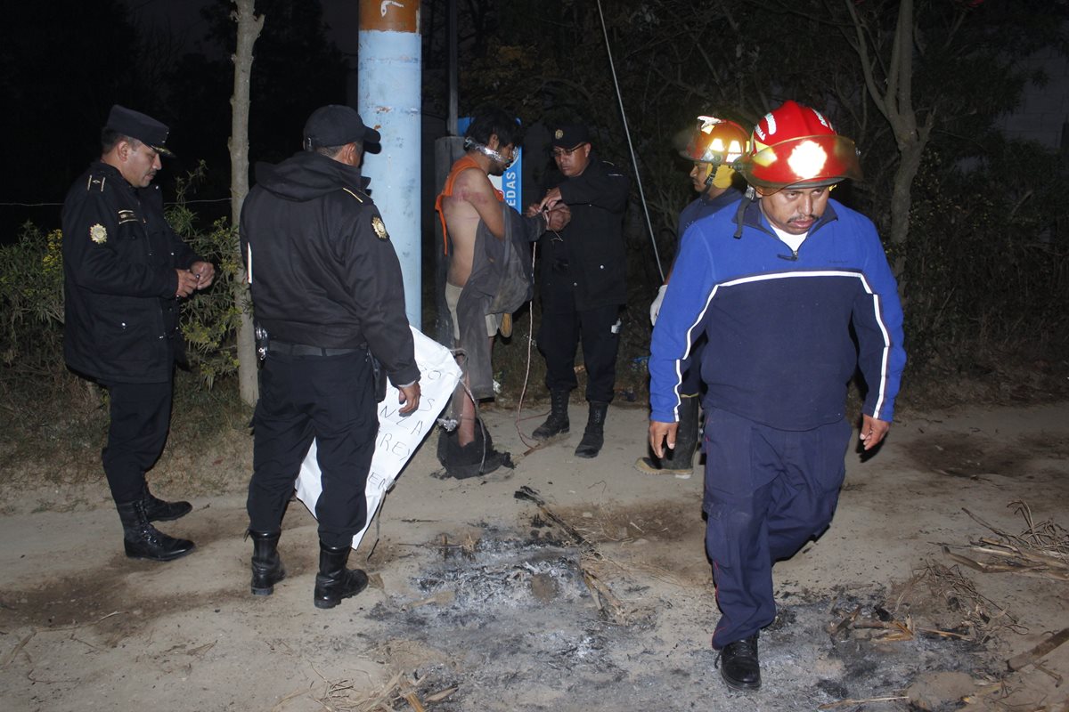 Bomberos y agentes de la PNC liberan a sujeto amarrado a un poste, en El Tejar. (Foto Prensa Libre: Víctor Chamalé)