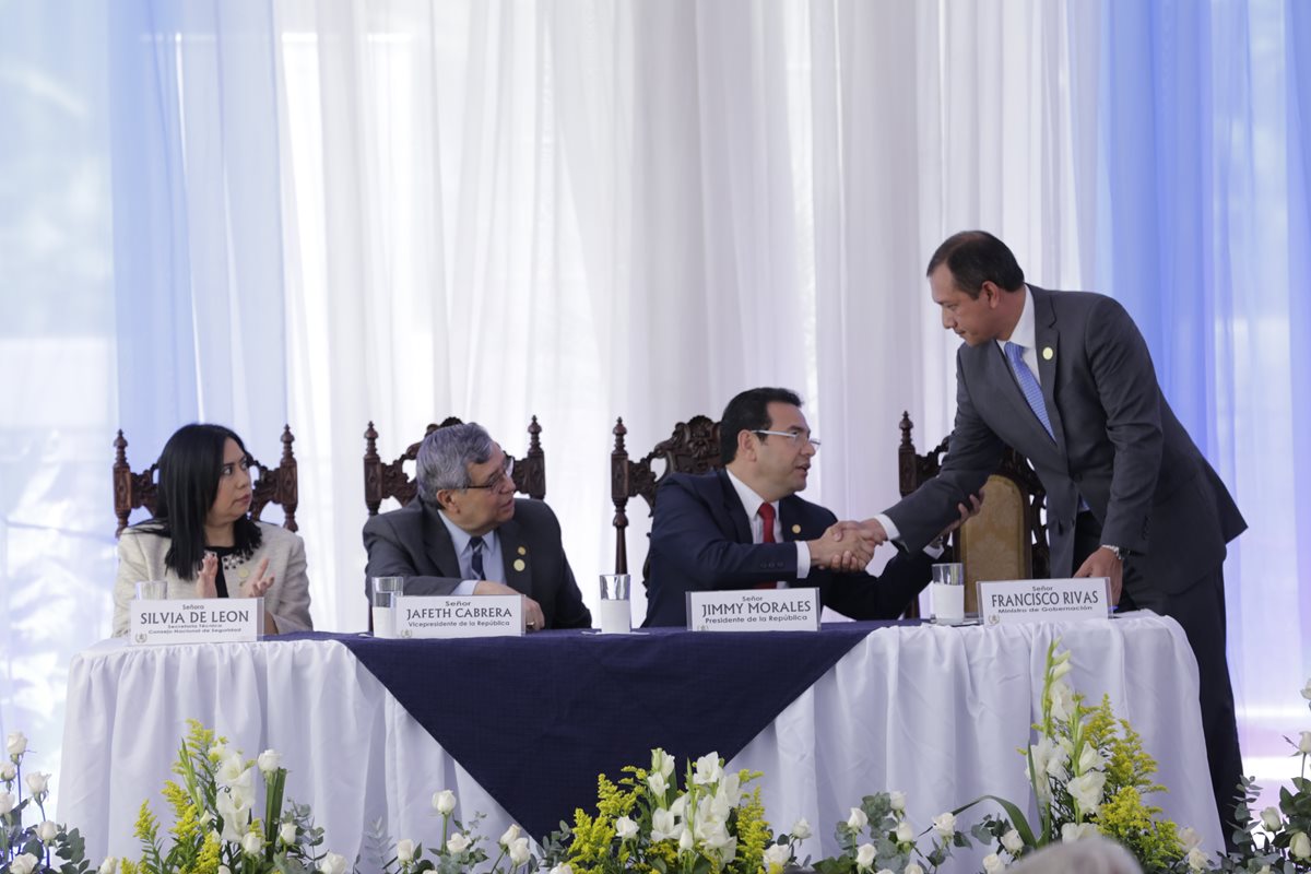 El presidente Jimmy Morales saluda al ministro de Gobernación, Francisco Rivas, durante la presentación de la Política Nacional de Seguridad. (Foto Prensa Libre: Paulo Raquec)